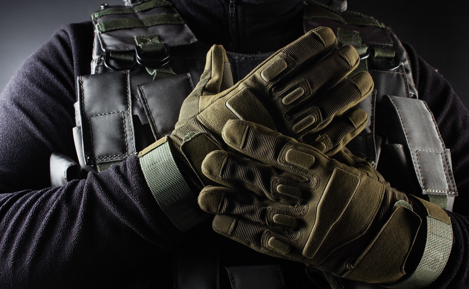 Soldier in black armor tactical vest and gloves standing.